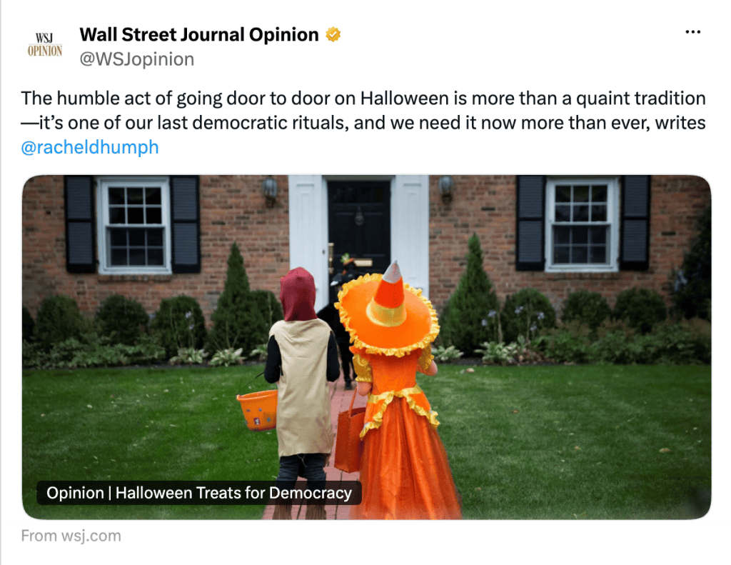 Two children dressed in Halloween costumes walking towards a house, one in a pumpkin outfit and the other in an orange dress with a large hat.
